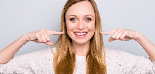 Woman Smiling and-Pointing at her White Teeth