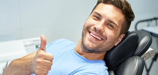 dental patient smiling giving thumbs up
